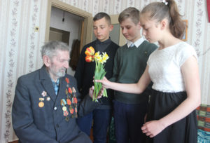Л. Молодожёнова, К. Павлюкевич, А. Подалевич поздравляют ветерана с праздником.