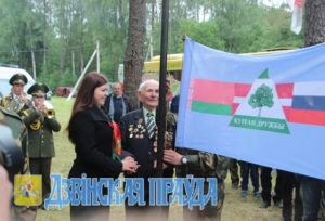 Флаг Кургана Дружбы поднимают  В. В. Дащёнок и Дарья Соколовская.