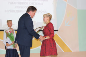Председатель райисполкома И. И. Маркович вручает награду за добросовестный труд учителю Бигосовской СШ Г. В. Тушкиной. 